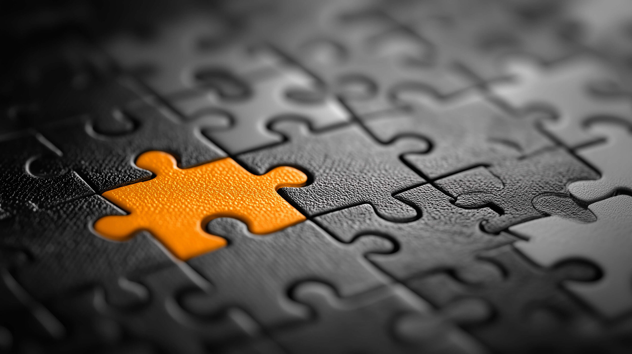 Oranges Puzzleteil in schwarzem Puzzle – Symbol für das fehlende Bindeglied und die Lösung durch Next Level by eurosill